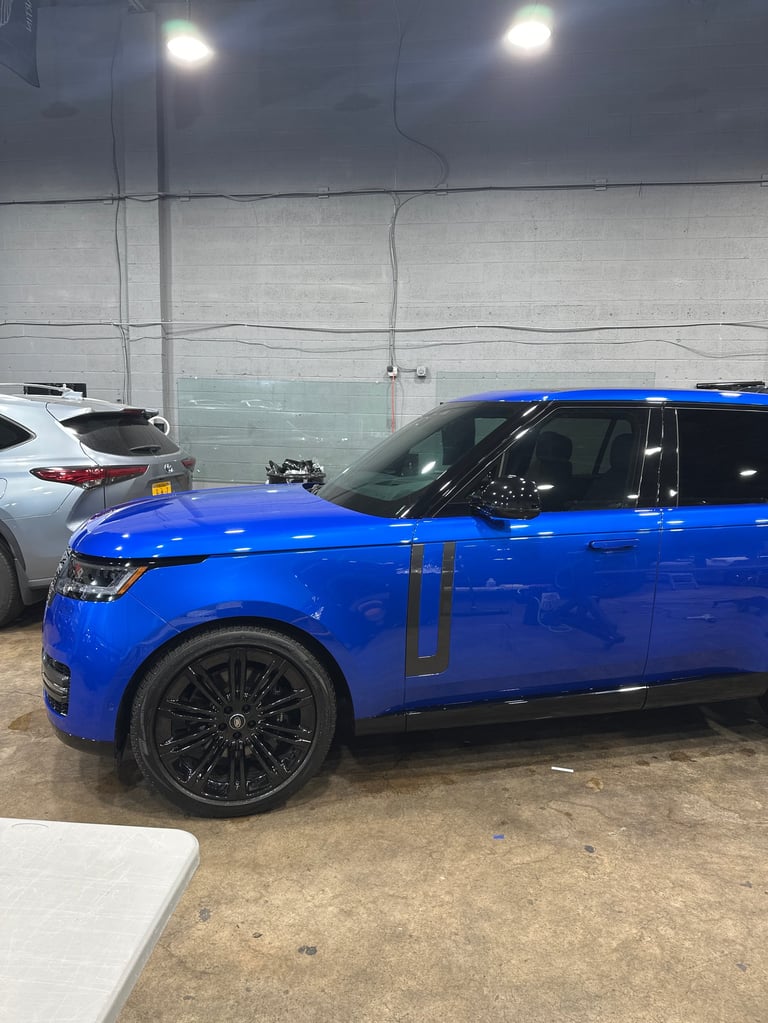 Bright blue SUV parked in a concrete garage with white and gray walls and overhead lighting